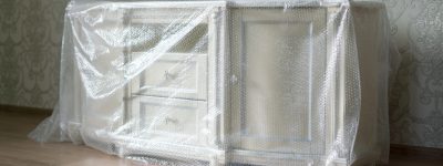 a new furniture delivered to the new flat apartment in the plastic protective material